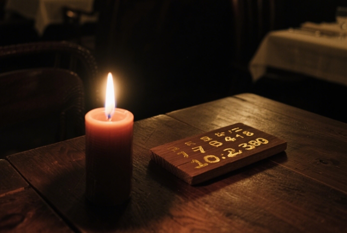 A lit candle, with a date overlay displayed next to it showing the unlit state
