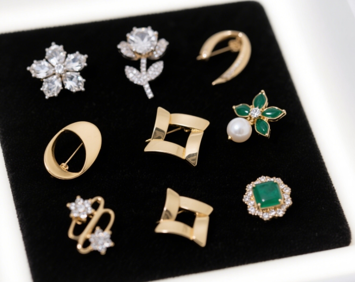 Display a variety of uniquely designed brooches laid out flat.