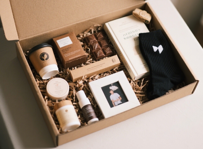 Open care package filled with personalized favorites like coffee, chocolate, book, and cozy socks