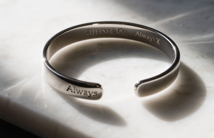 Tiffany & Co. Atlas X Open Bangle with “Always” engraving on a minimalist background