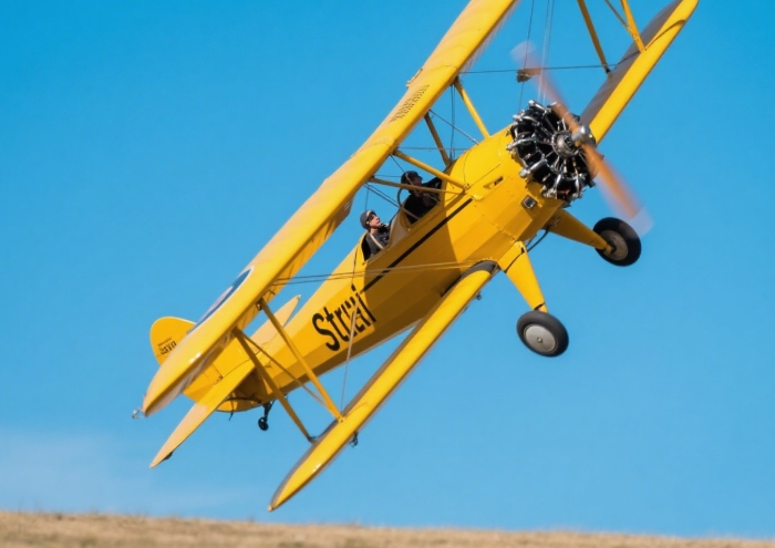 Vintage yellow biplane performing aerial loop - extreme anniversary adventure gift flight