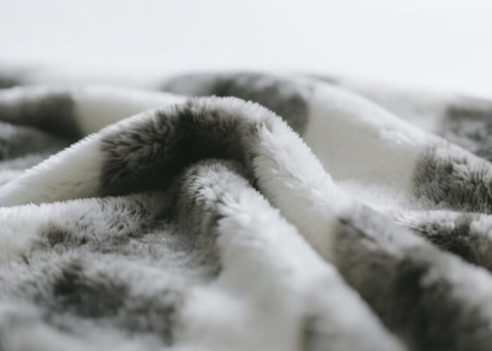 Extreme close-up of a super soft, plush grey faux fur throw blanket texture for tactile soothing