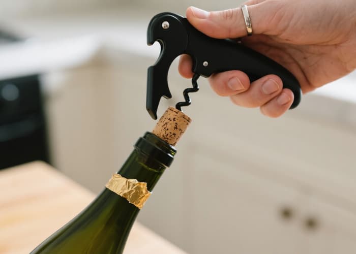 The sleek opener effortlessly removing a cork from a bottle. Show it being held comfortably